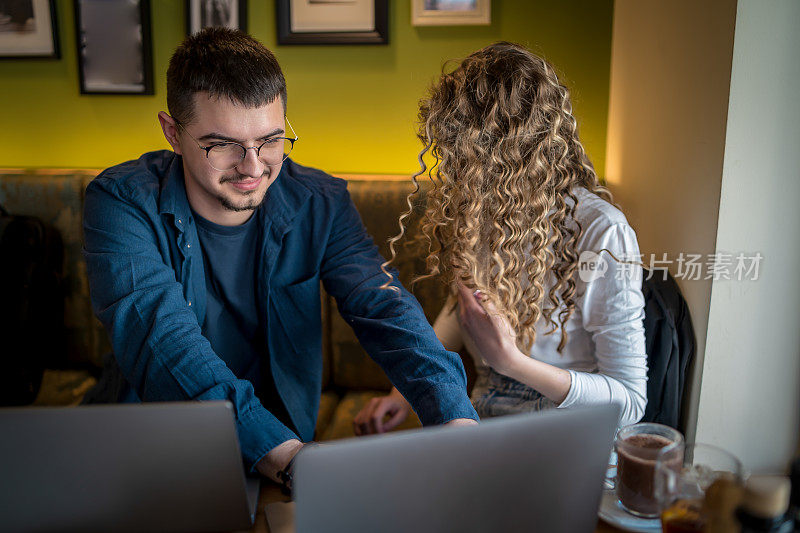 Business people working together at a café using their laptops